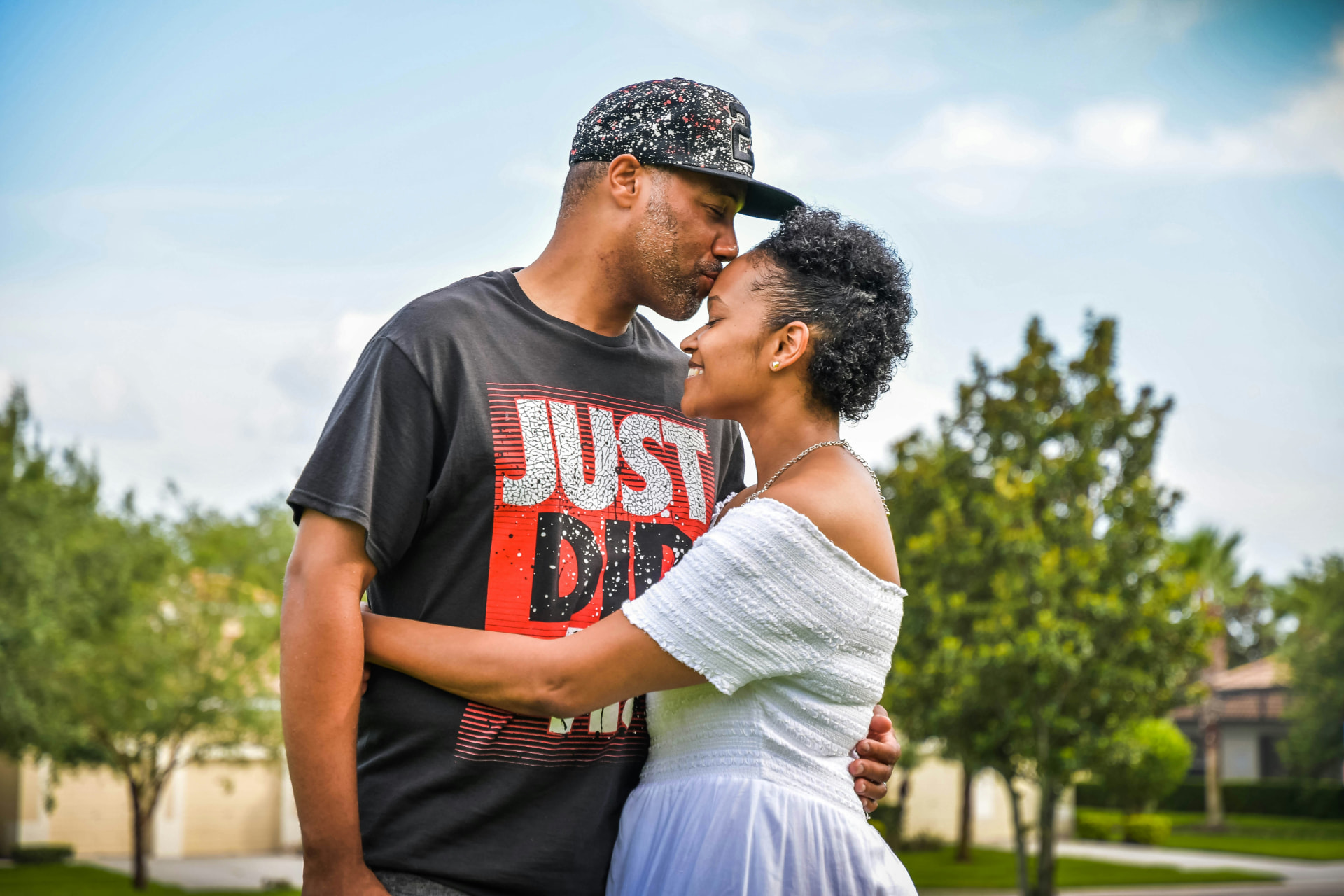 A joyful Black couple sharing an affectionate moment outdoors